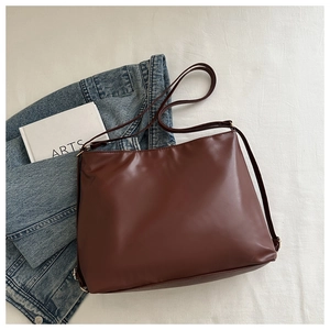 Gros plan du cabas minimaliste en cuir PU marron foncé avec boucle en métal doré chic