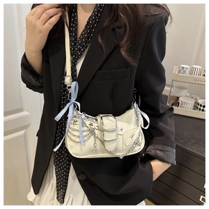 Chic off-white underarm bag with metal chains, star charms, and blue plaid bow detail
