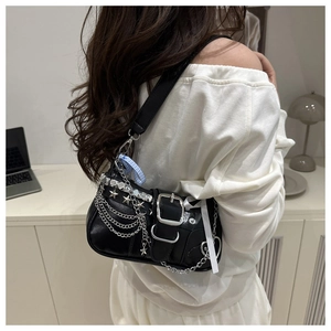 Close-up of black Y2K underarm bag with silver chains and star rivets in lifestyle view