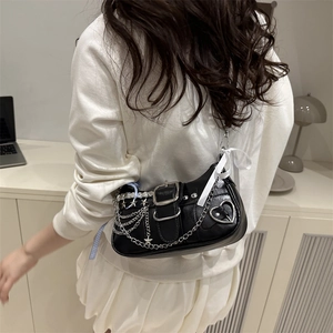 Punk black leather shoulder bag with silver chains, star studs and a white ribbon detail