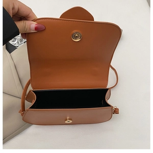 Detail showing brown leather shoulder bag interior with magnetic snap closure mechanism