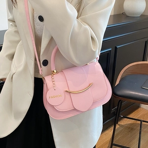 Pink PU leather crossbody bag with gold crescent buckle and fashion charm, model lifestyle view