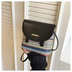 Detailed view of the colorful woven texture and black leather flap with gold metal logo