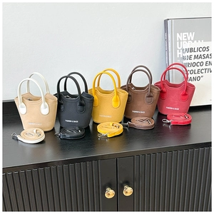 Dettaglio di cinque mini borse shopping colorate in pelle con tracolle coordinate