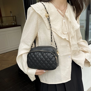 Klassische schwarze Stepptasche mit verstellbarer Goldkette, getragen von einem Modell