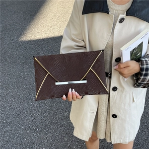 Pochette enveloppe marron foncé à texture serpent et bordure métallique style urbain