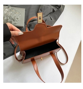 Detail view of the brown PU handbag showing the interior lining and gold twist lock closure