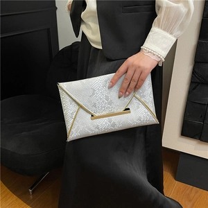 Pochette enveloppe argentée motif serpent avec bordure dorée et fermoir barre minimaliste