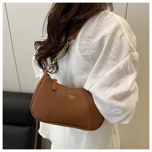 Close-up of brown litchi pattern leather bag with gold chain strap and fashion logo