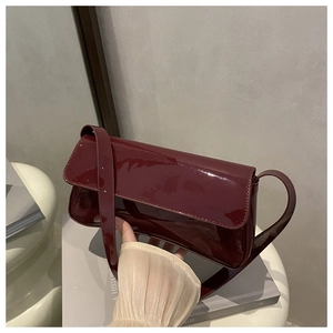 Détail du sac baguette en cuir verni rouge foncé avec fini miroir et coutures
