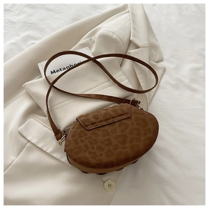 Close-up of brown leopard print texture and golden hardware on the shell crossbody bag