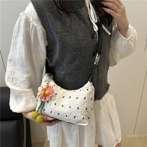 White pleated crossbody bag with black embroidery and floral charm on wide strap