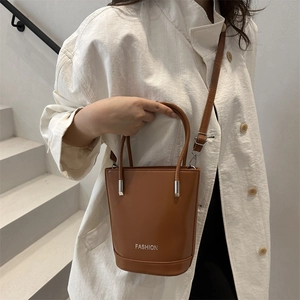 Brown vintage vertical bucket bag with top handle and adjustable shoulder strap