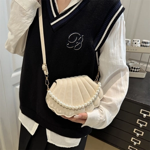 Elegant off-white shell-shaped crossbody bag with pearl strap and refined PU texture