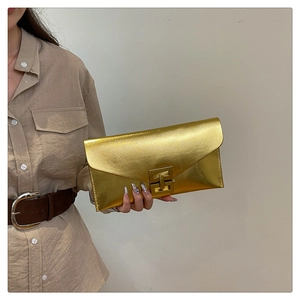 Détail de la pochette enveloppe dorée avec texture brossée et boucle en bronze