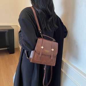 Brown vintage faux leather backpack with metallic rivets and stylish top handle design