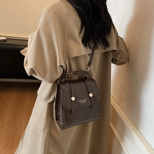 Vintage dark brown leather backpack with golden buckles and shoulder strap for women