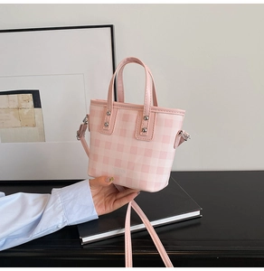 Nahaufnahme der rosa-weißen Mini-Beuteltasche mit Karomuster, Nieten und Tragegriff