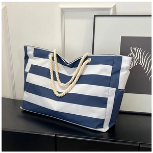 Detail of blue and white striped canvas tote bag with thick rope handles and side pocket