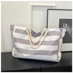 Detail of grey striped canvas tote bag with thick cotton rope handle and side pocket
