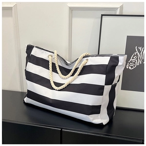Detail of striped canvas tote with cotton rope handles and functional side pockets