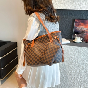 Retro plaid tote bag and matching clutch set shown on shoulder in a minimalist setting