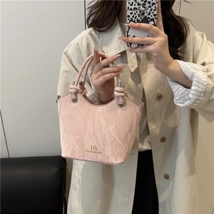 Sac seau rose pour femme avec texture marbre, logo doré et double poignées supérieures