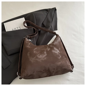 Detail of vintage brown hobo bag with cloud-dyed texture and silver adjustable buckle