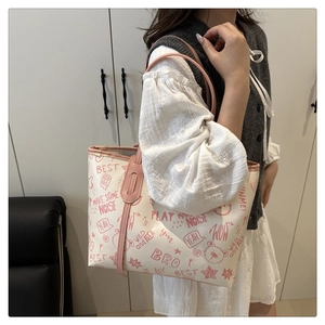 Detail of printed tote bag featuring artistic pink graffiti letters and bear patterns