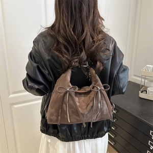 Retro dark brown pleated leather tote bag with silver zippers and bow details