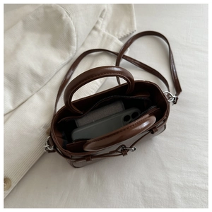 Internal view of brown leather handbag showing phone storage capacity and metal zipper detail