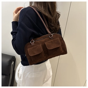 Close-up of vintage dark brown faux suede shoulder bag with dual flap pockets