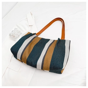 Close-up of color-block striped tote bag showing woven texture and leather handle