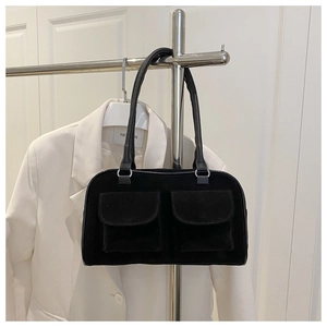 Detail view of black faux suede shoulder bag with dual front pockets and silver rings