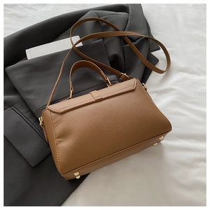 Détails d'un sac à main en cuir grainé marron avec clous de protection dorés au fond