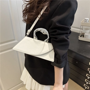 Minimalist white leather crossbody bag with asymmetric design and silver metal handle