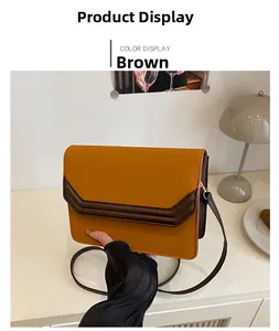 Detail of a brown rectangle flap shoulder bag with V-shaped stitching and leather strap