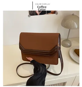 Detail of coffee brown PU leather shoulder bag with dark stitching and slim strap