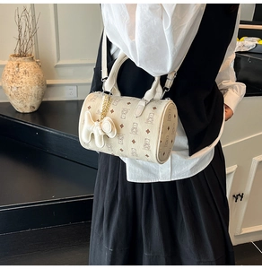 Sac Boston beige à motif d'ours et charm chien porté en sac à bandoulière chic