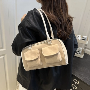 Minimalist beige canvas crossbody bag with white trim and silver buckles on a female model