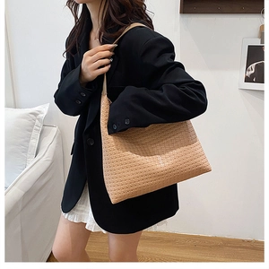 Chic beige woven tote bag styled with a blazer, showing its large capacity and elegant drape