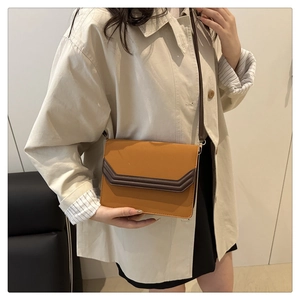 Close-up of retro rectangular crossbody bag in ginger PU leather with V-shaped flap detail