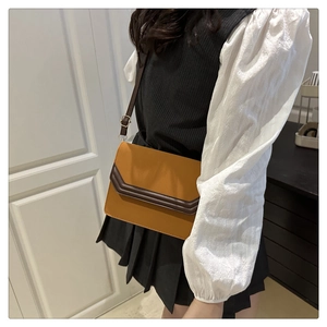 Detail of vintage square crossbody bag showing rich brown faux leather and contrast trim