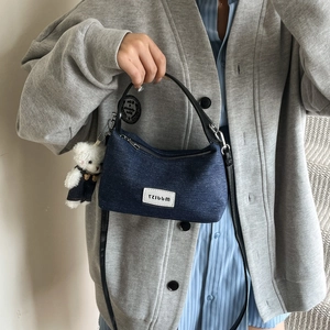 Borsa a tracolla in denim blu scuro a mezzaluna con ciondolo a forma di orsetto
