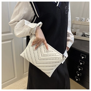 Detail of white quilted envelope bag with silver studs and smooth zip closure