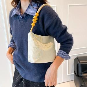 Bamboo style embroidery underarm bag with decorative yellow beads on shoulder strap