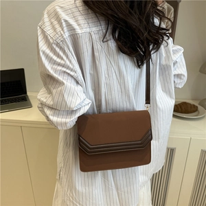 Minimalist brown patchwork leather crossbody bag for women shown in a modern daily setting