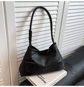 Vue détaillée du cuir tressé noir et de la bandoulière sur un sac à main minimaliste