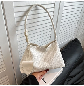 Détail du sac hobo blanc à texture tressée avec un mini porte monnaie rond assorti