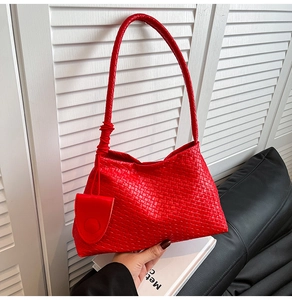Détail du sac hobo rouge tressé avec une petite pochette ronde assortie amovible